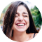 A happy woman smiling with long hair and red lipstick.