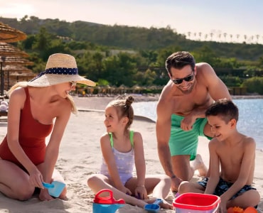 Family enjoying a sunny day building sandcastles on the beach.
